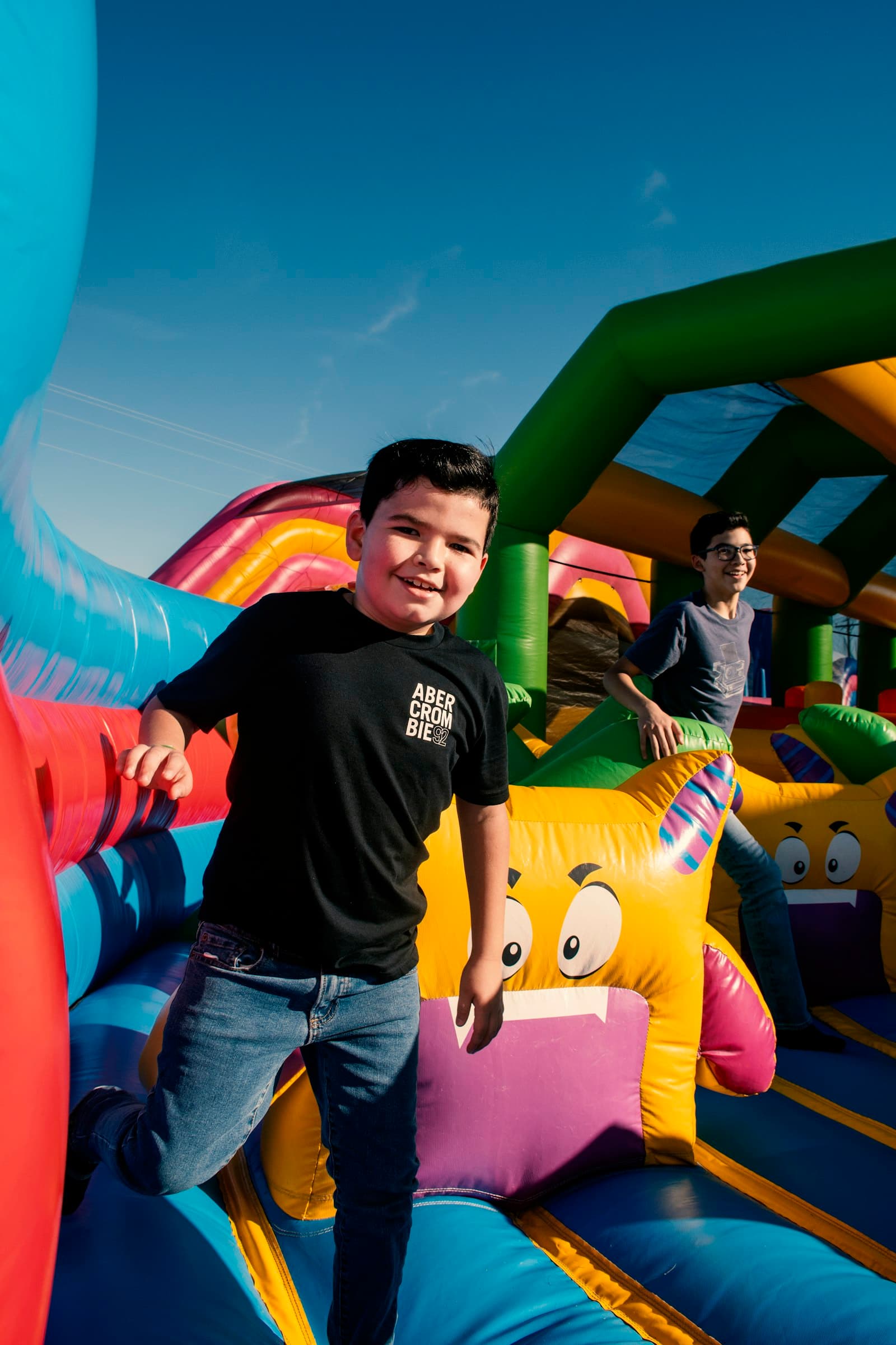 Niños saltando dentro de un castillo inflable de colores